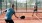 a person hitting a ball with a pickleball paddle to another person